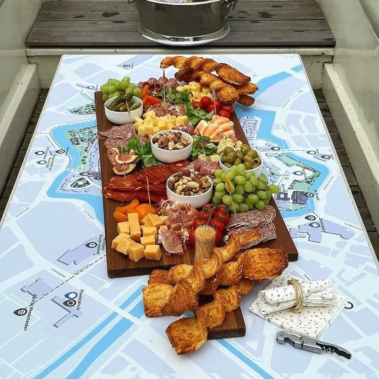 Rijkgevulde borrelplank met kaas en vleeswaren op de stadskaart-tafel aan boord